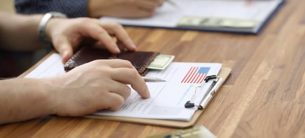 A close up shot of a United States Veteran signing documents for a VA Loan at a table with a loan officer.