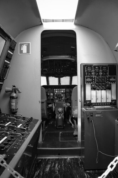 A black-and-white photograph depicting the interior of a radar operations room during the Battle of Britain. The image shows RAF personnel, mostly women, tracking the movements of aircraft on a large map table.