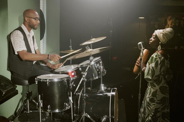 A military band performing live for troops in a combat zone. The band is playing modern instruments and the soldiers are shown smiling and clapping along to the music. The scene shows a moment of joy and camaraderie amidst a challenging environment.