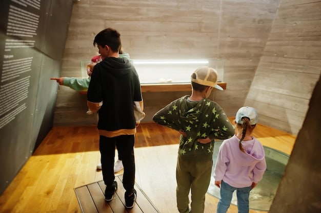 A group of students participating in a guided tour at a military museum, with a docent explaining the historical significance of an exhibit. The scene highlights the educational outreach of the museum.