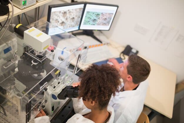 Engineers examining a complex, metallic 3D-printed component on a workbench in a modern defense research laboratory, with technical drawings and computers in the background.
