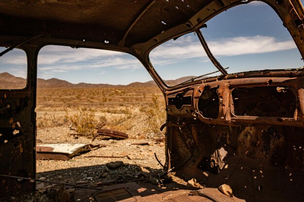 A military jeep driving through a parched desert landscape under a harsh sun, symbolizing the impact of climate change on defense operations.