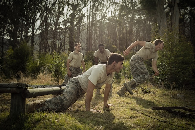 US Army soldiers participating in a rigorous combat training exercise, emphasizing physical and tactical readiness under simulated conditions.