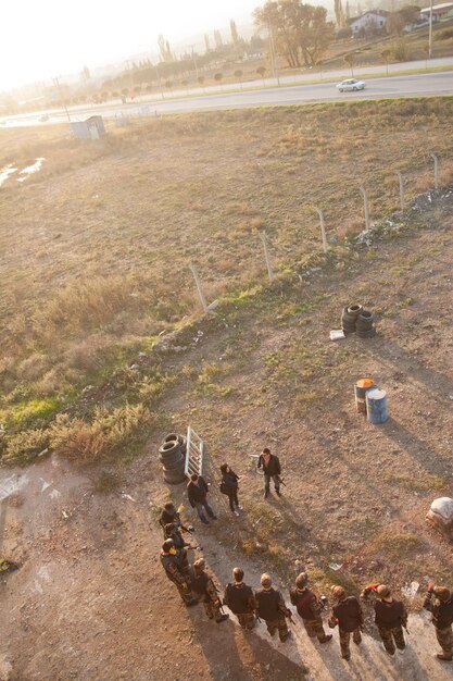 High-angle drone shot of a joint US and Japanese military humanitarian aid and disaster relief (HADR) operation in action, showing helicopters airlifting supplies to a devastated area, medical tents set up, and coordination centers amidst debris.