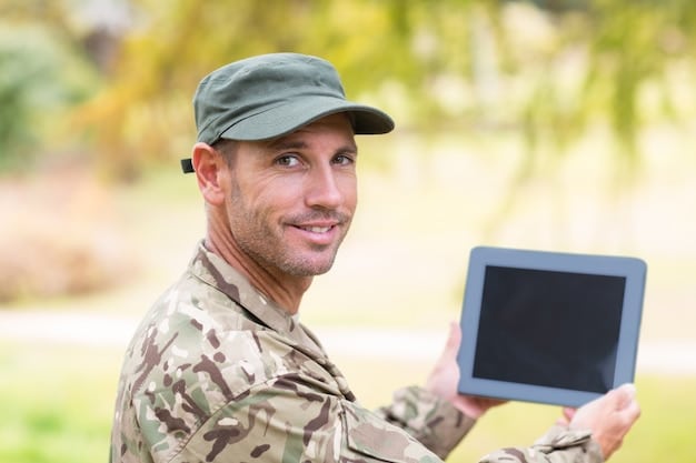 A U.S. Army soldier intently viewing a tablet display showing real-time feedback from a small, agile RCV scouting ahead in a dense urban environment, highlighting remote operation and situational awareness.
